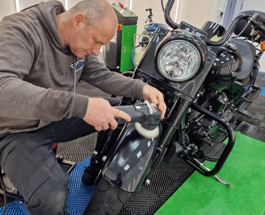 Motorcycle being detailed with a machine polish